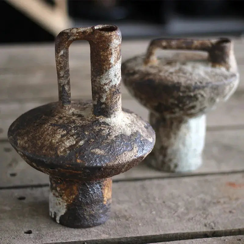 Two rusty metal weights on a wooden surface