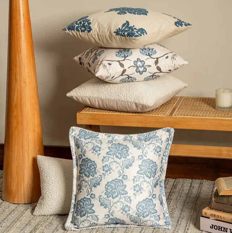 Stack of floral patterned pillows on a wooden table