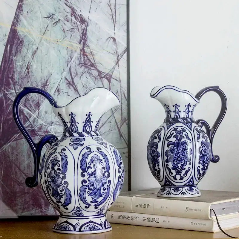 Two blue and white ceramic jugs on books with a abstract art