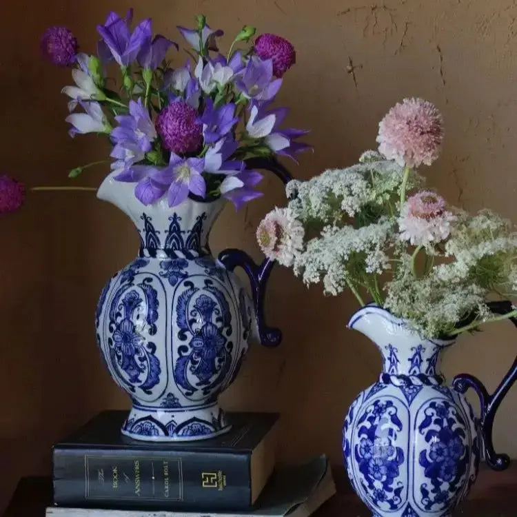 Two blue and white ceramic vases with floral arrangements