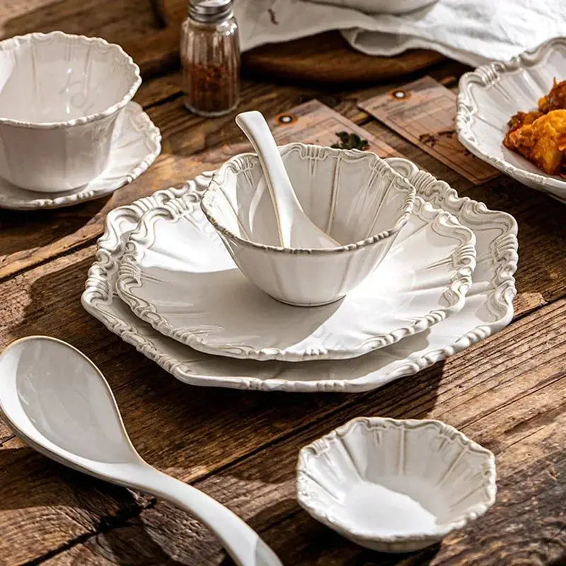 White ceramic dishes on a wooden table with a rustic setting