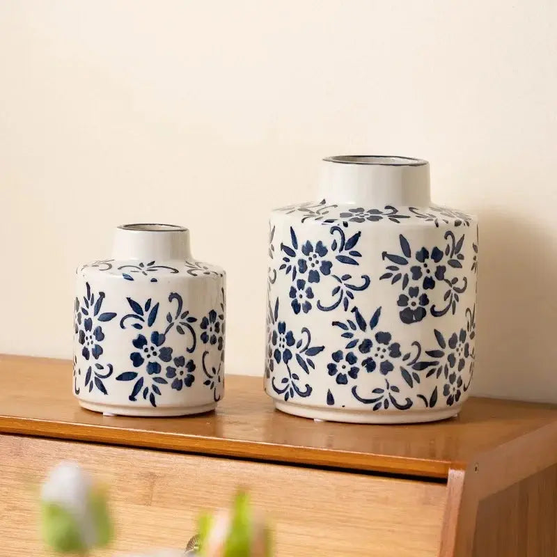 Two ceramic vases with blue floral patterns on a wood