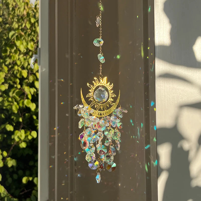 Decorative sun and moon hanging ornament with crystals on a dark surface.