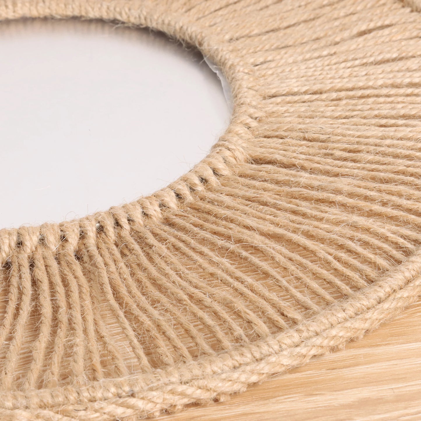 Close-up of a woven circular mat with natural fiber texture on a light background