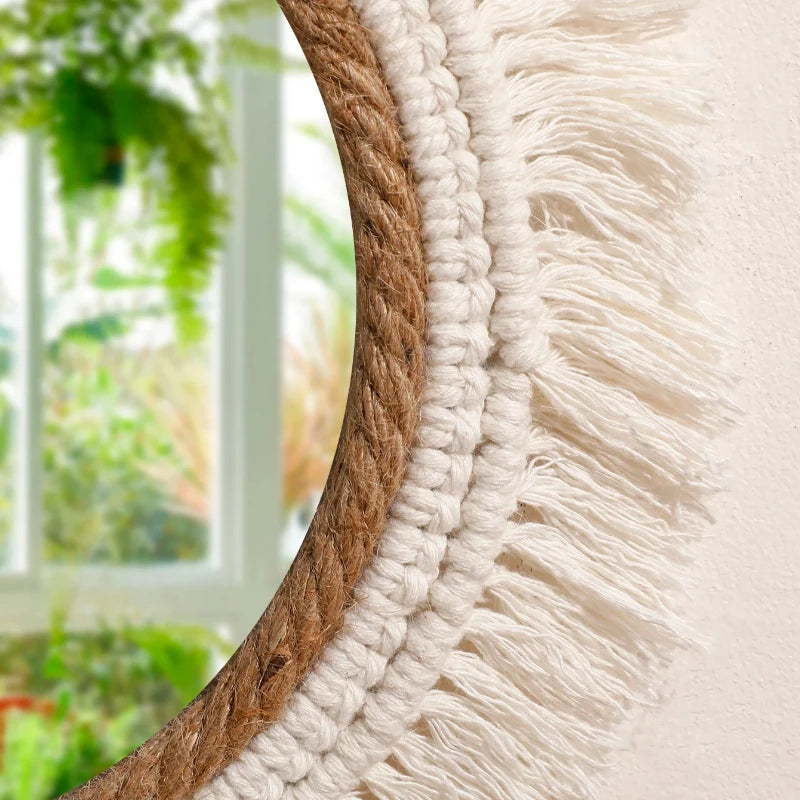 Close-up of a round mirror with a wooden frame and white macramé border, blurred greenery in the background