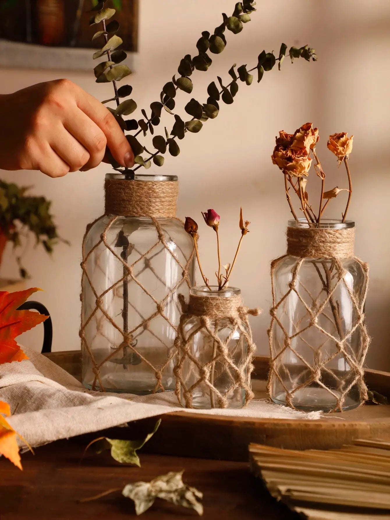 Decorative glass jars with twine wrapping on a wood