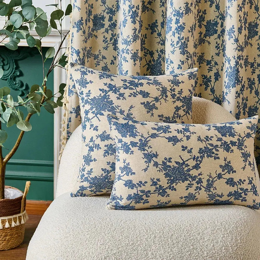 Floral-patterned cushions on a sofa with decorative plant