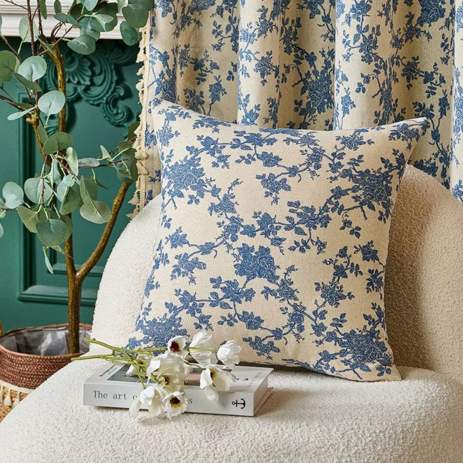 Floral-patterned pillow on a chair with decorative elements in the background