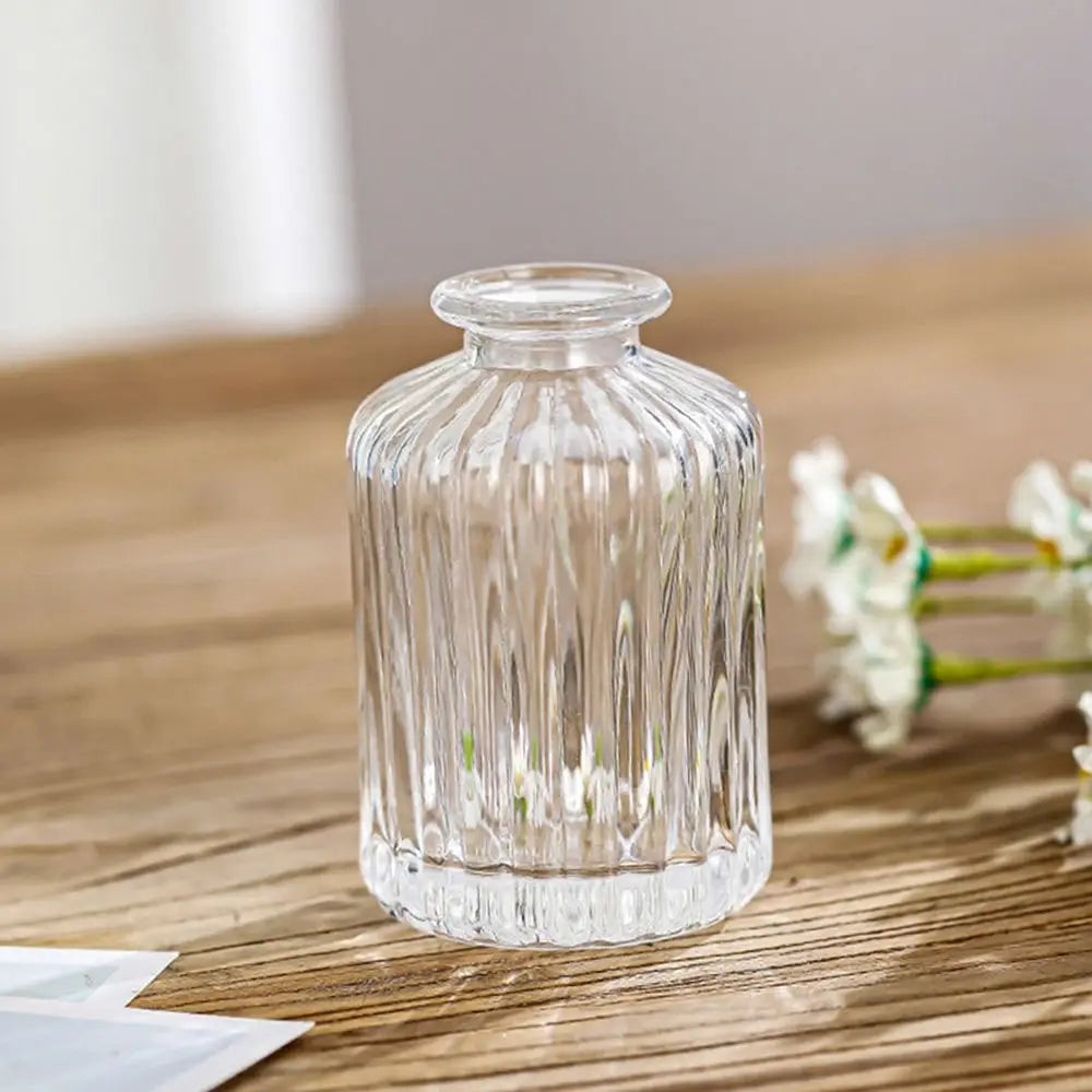 Clear glass vase on a wooden surface with a blurred background