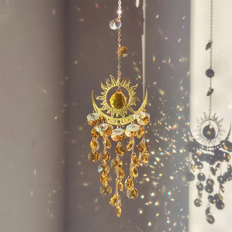 Decorative sun and moon hanging ornament with crystals on a reflective surface.