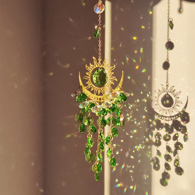 Decorative hanging ornament with green gemstones and gold accents on a neutral background
