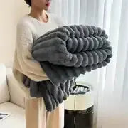Person holding a gray blanket in a living room setting