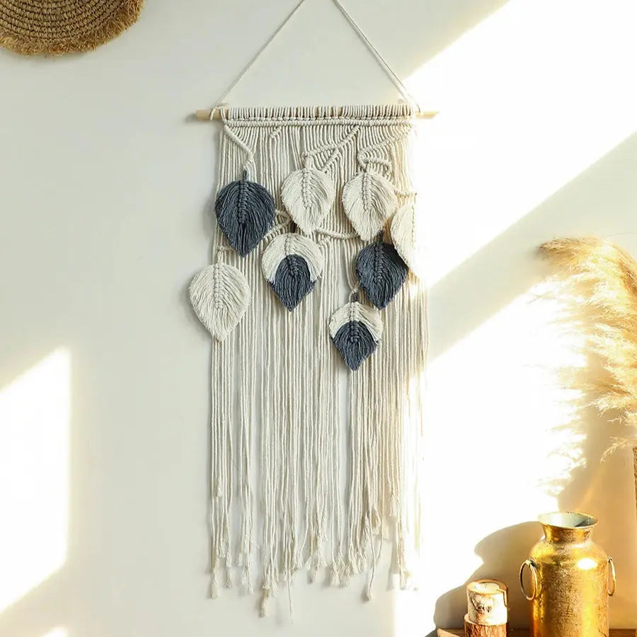 Macrame wall hanging with leaf patterns on a white wall