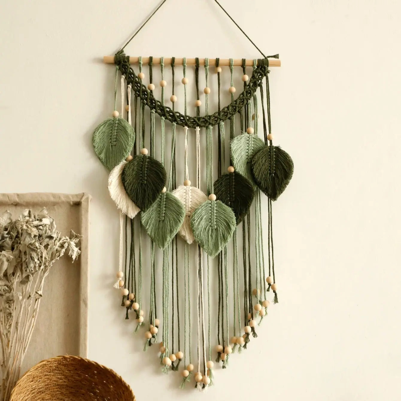 Decorative wall hanging with green leaves and string