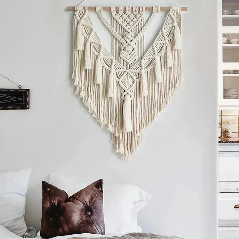 Macrame wall hanging above a bed with pillows