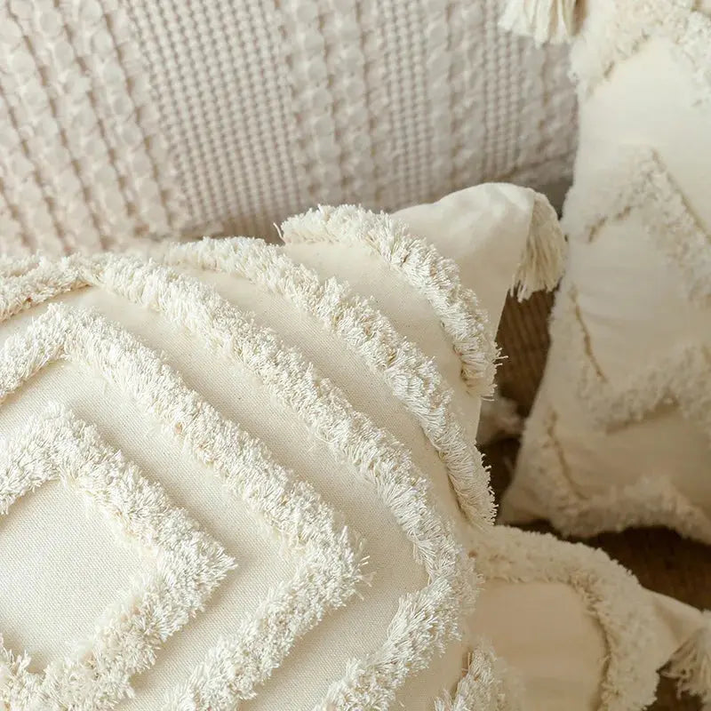 Close-up of textured beige pillows with fringes