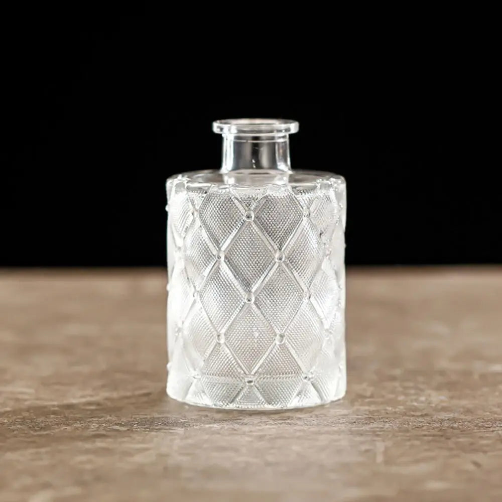 Decorative glass bottle with textured design on a wooden surface