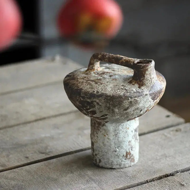 Vintage ceramic pot with a handle on a wooden surface
