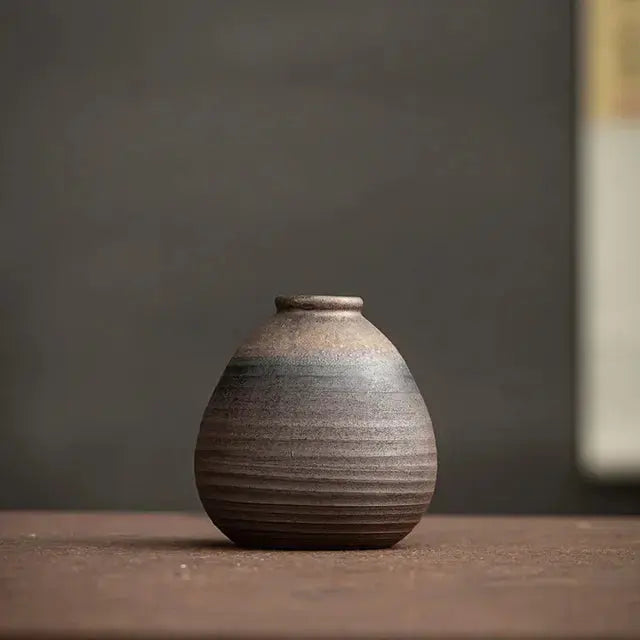 Stoneware vase on a wooden surface with a dark background