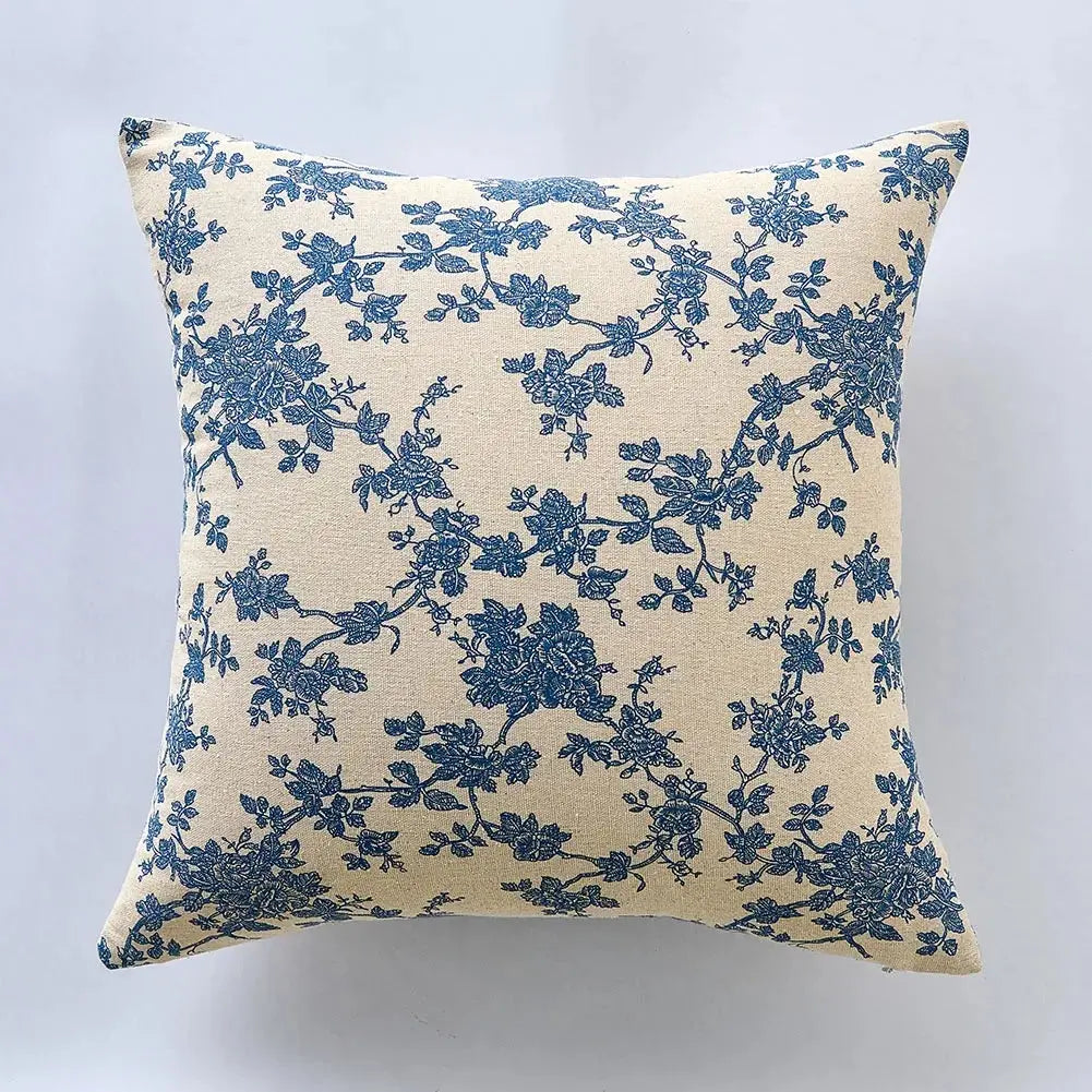 Floral-patterned cushions on a sofa with decorative plant