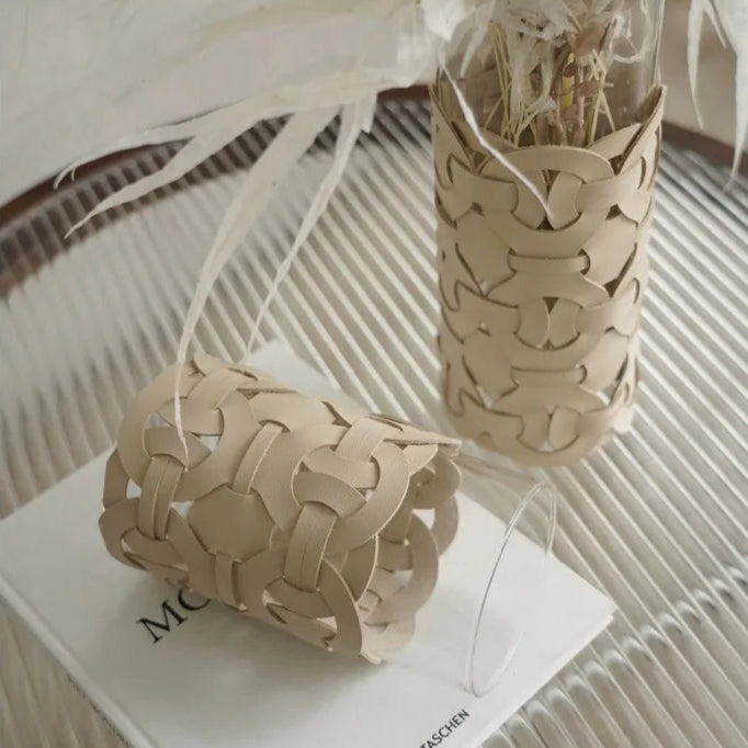 Two woven paper vases on a white surface with text