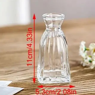 Clear glass vase on a wooden surface with measurements indicated
