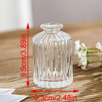 Set of clear glass vases on a wooden surface with measurements indicated.