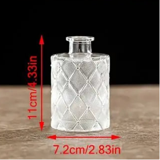 Clear glass bottle with diamond pattern on a wooden surface, measurements indicated.