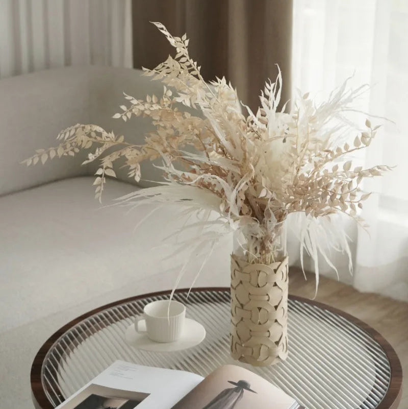 Decorative vase with dried plants on a coffee table in a living room setting