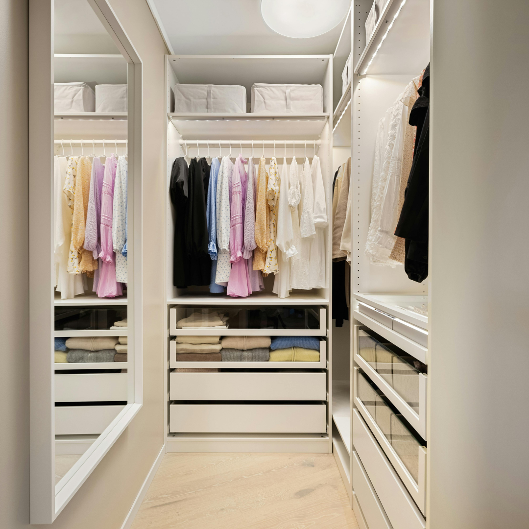 Modern walk-in closet with organized clothes and shelves.