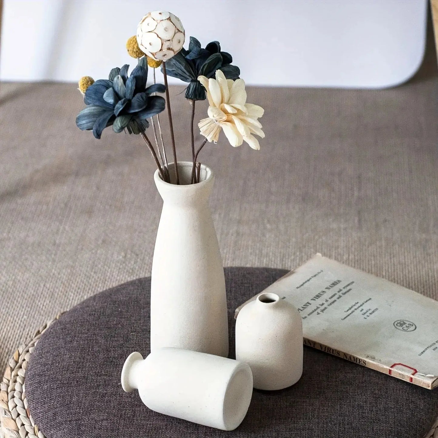 White ceramic vase with flowers on a textured surface