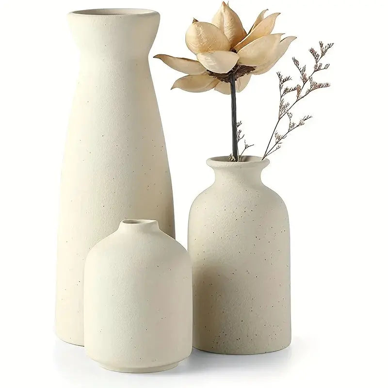 Set of three ceramic vases with textured finish on a white