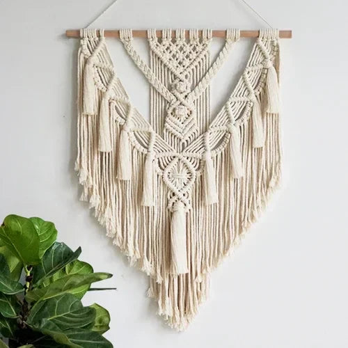 Macramé Wall hanging on white wall with plant