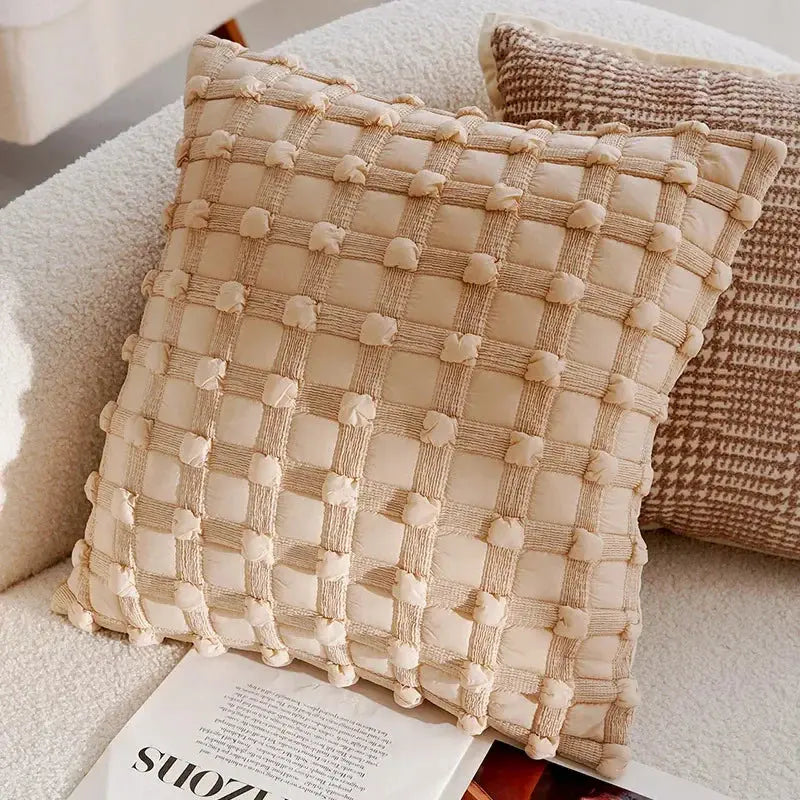 Textured woven pillow on a sofa with a magazine underneath