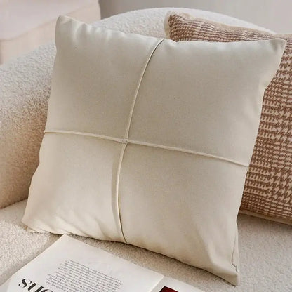 Beige pillow on a sofa with a magazine underneath
