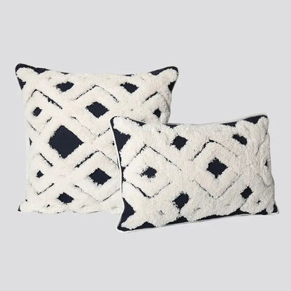 Two decorative pillows with geometric patterns on a light gray background