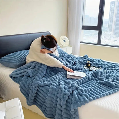 Person lying on a bed covered with a blue blanket in a room 
