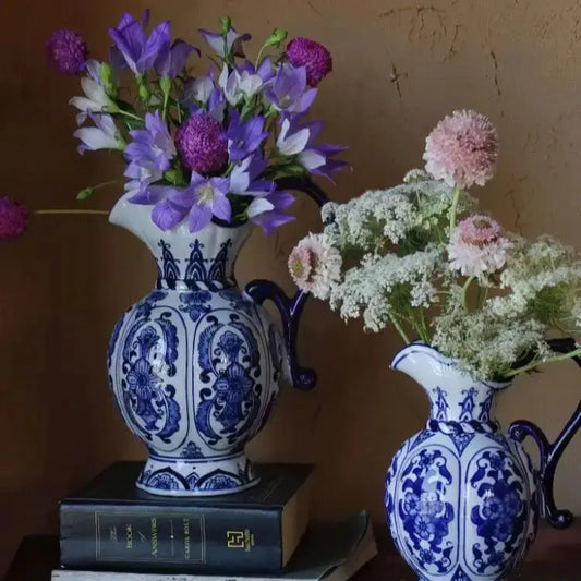 Two blue and white ceramic vases with floral arrangements