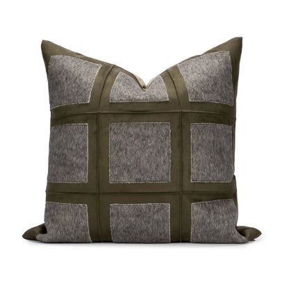 Decorative pillow with a patchwork design featuring gray and green colors on a white background.