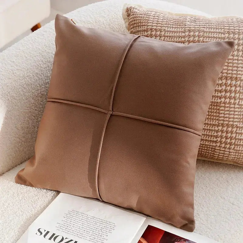 Brown pillow on a sofa with a magazine underneath