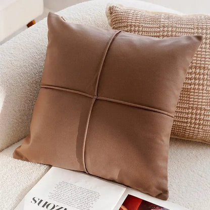 Brown pillow on a sofa with a magazine underneath