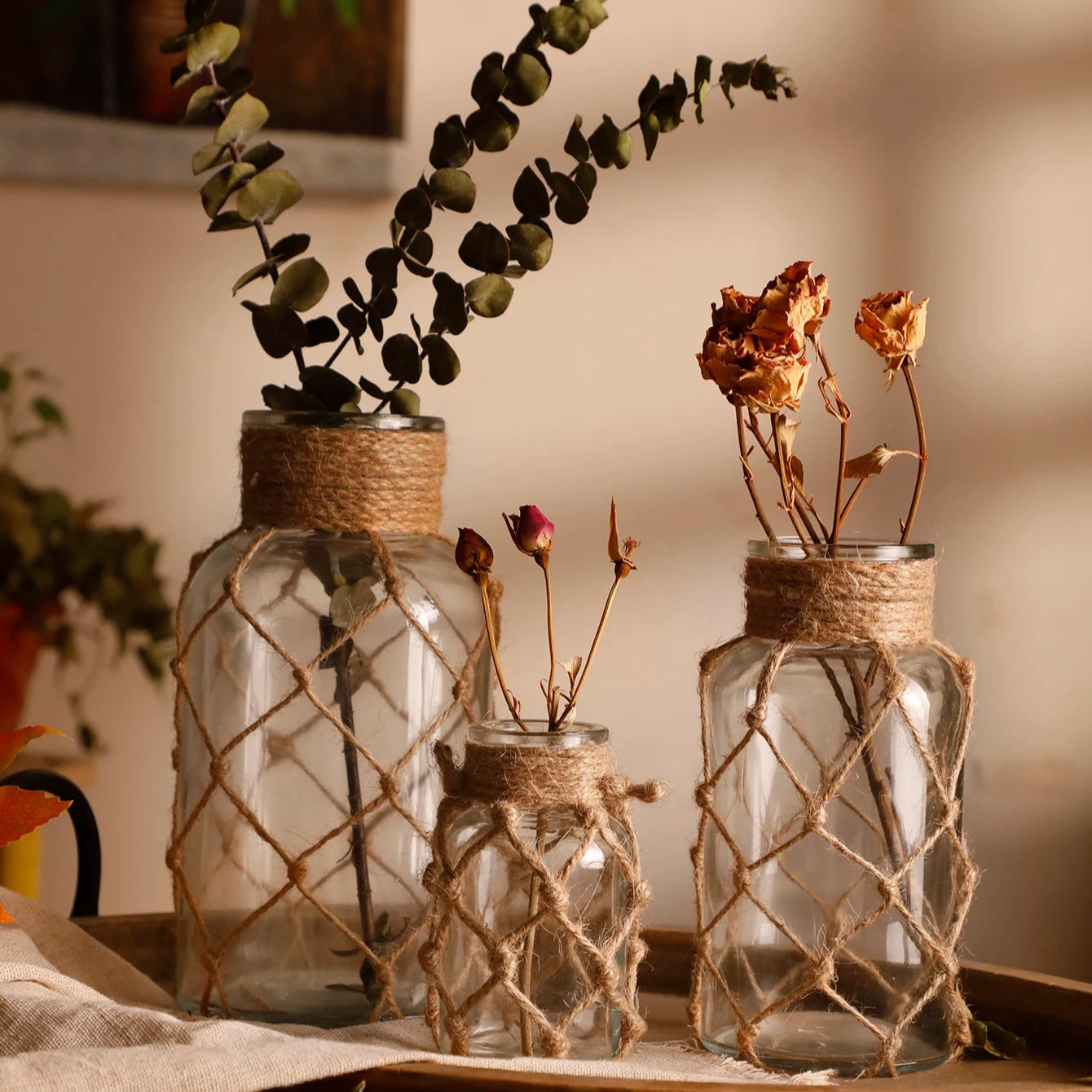 Three glass jars with textured surfaces and twine accents on a wooden surface.