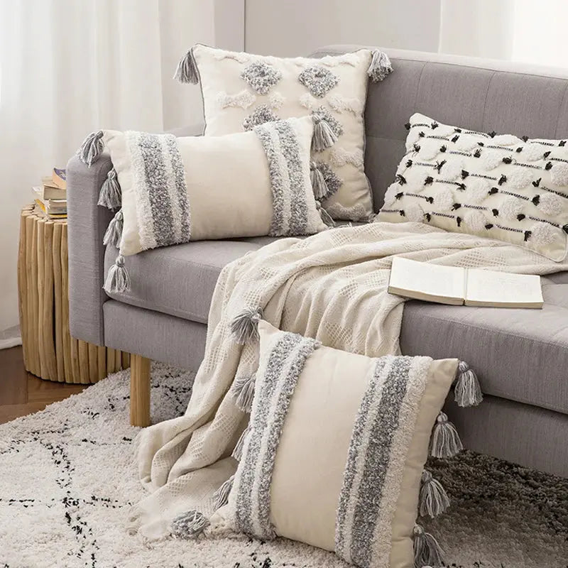 Gray sofa with decorative pillows and a blanket in a living room setting