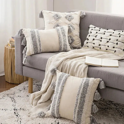 Gray sofa with decorative pillows and a blanket in a living room setting