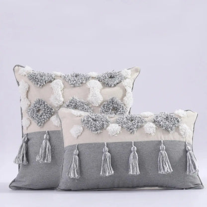 Two decorative pillows with tassels on a light gray background