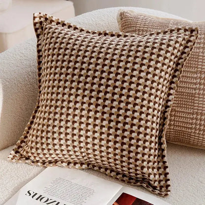 Patterned pillow on a sofa with an open magazine underneath