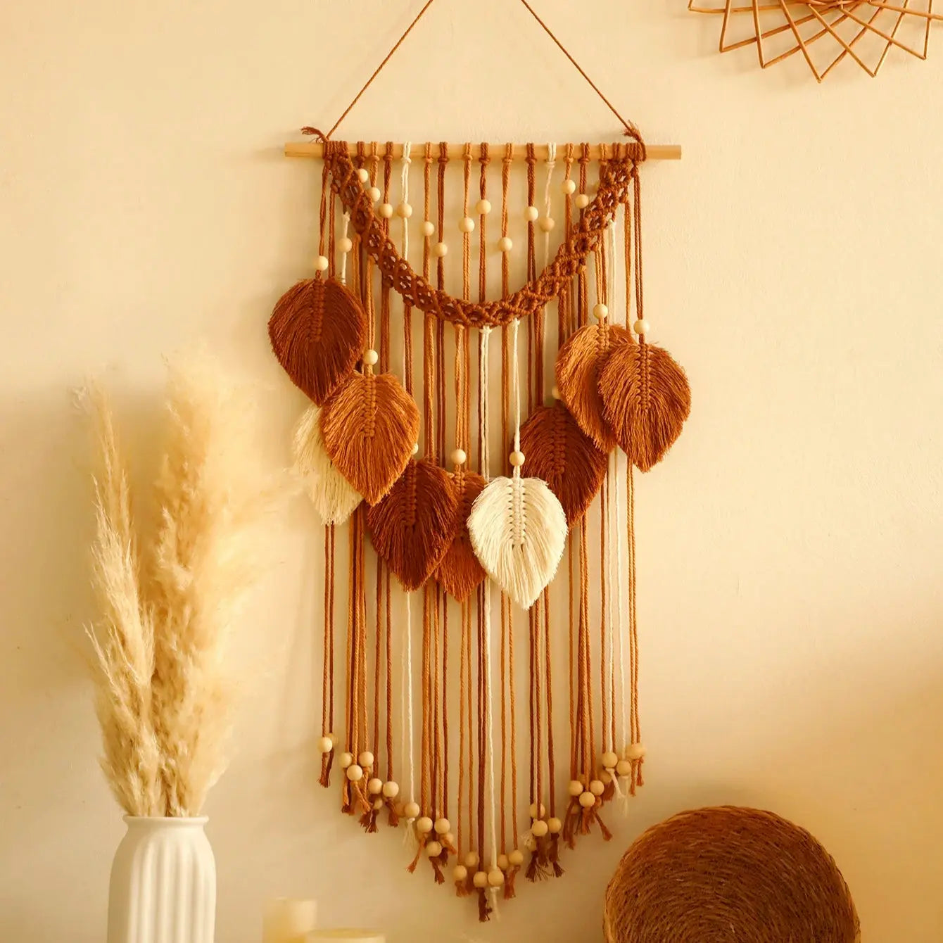 Woven wall hanging with decorative elements on a beige wall.