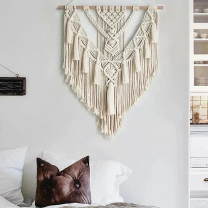 Macrame wall hanging above a bed with pillows