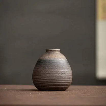 Stoneware vase on a wooden surface with a dark background