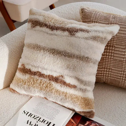 Decorative pillow with striped pattern on a sofa next to a magazine